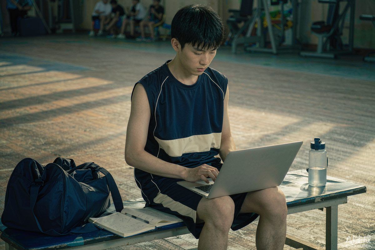 A student athlete studying on a laptop between training sessions